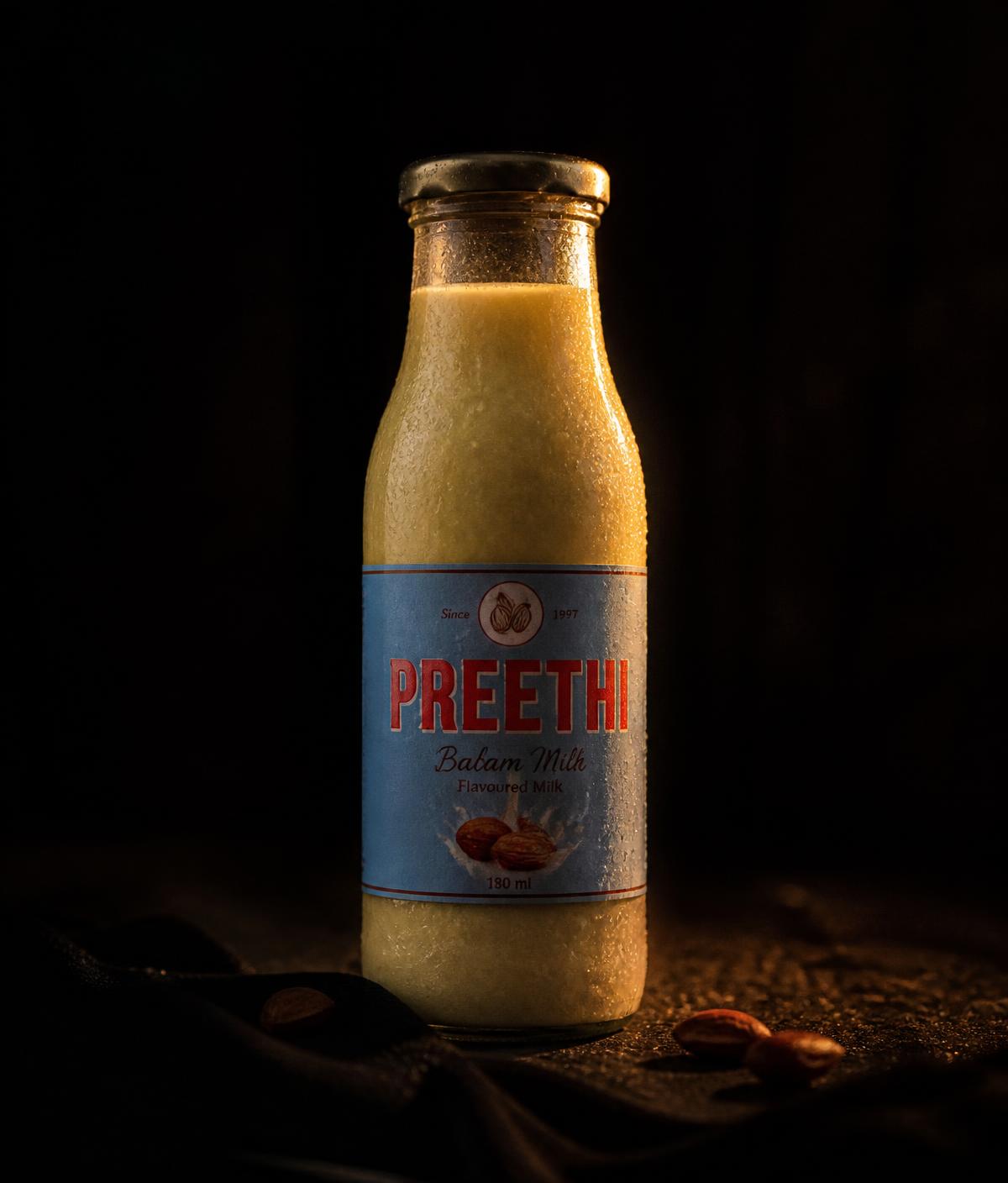 A capped glass bottle of badam milk lit in the dark